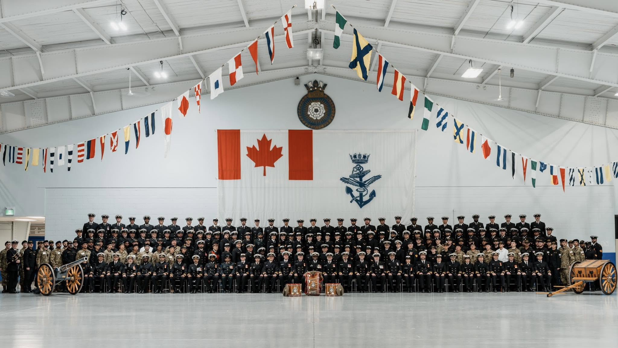 HMCS YORK ship’s company assembled beneath the Canadian flag